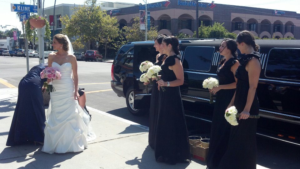 Young bride in white gown with six bridesmaids and the black Cadillac escalade