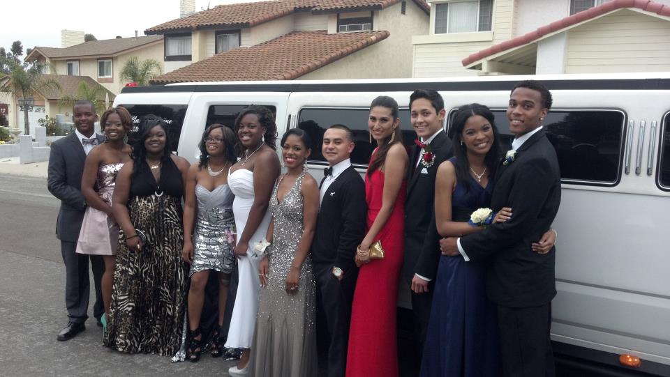 several young adults in formal wear standing next to stretch limousine hummer h2 from A Plus Limos
