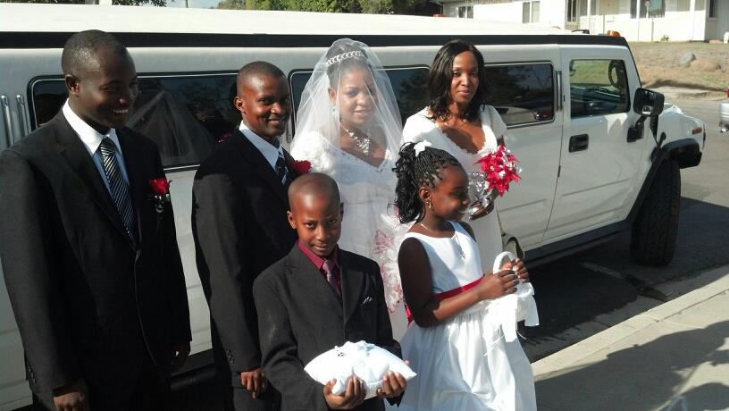 Bride, groom, bestman, maid-of-honor, flower girl and ring boy choose with white hummer limo