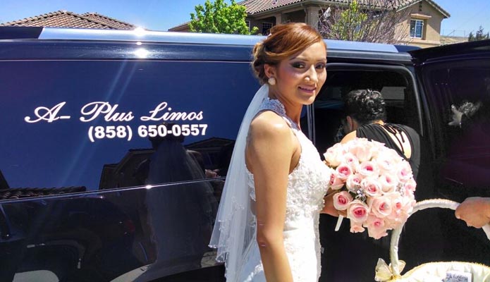 San Diego bride in white dress and bouquet getting into a limousine
