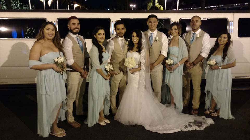 wedding party standing next to a plus limos hummer