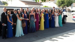 several young couples in formal wear standing with white hummer limo from A Plus Limos